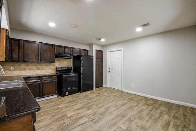 9923 Valley Sun Dr, Houston, TX 77078 - kitchen featuring black appliances, a sink, under cabinet range hood, light wood finished floors, and decorative backsplash