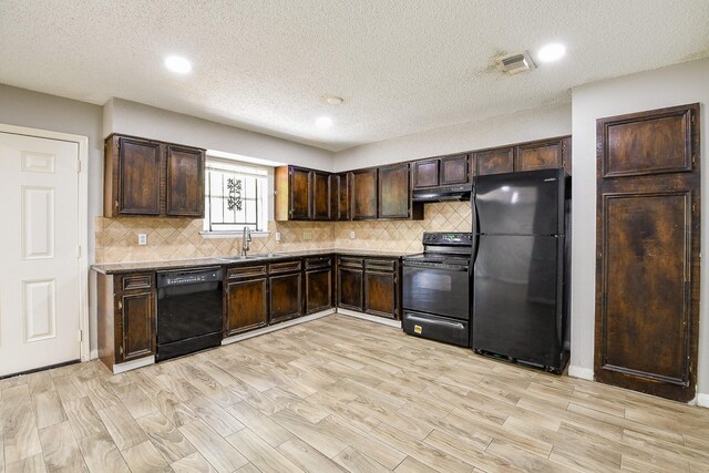 9923 Valley Sun Dr, Houston, TX 77078 - kitchen with black appliances, a sink, under cabinet range hood, dark brown cabinets, and light wood-style flooring