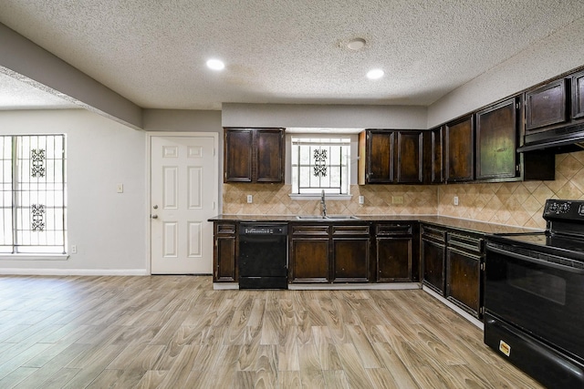 9923 Valley Sun Dr, Houston, TX 77078 - kitchen with black appliances, a textured ceiling, under cabinet range hood, light wood-type flooring, and a sink
