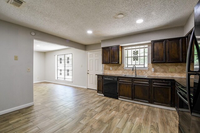 9923 Valley Sun Dr, Houston, TX 77078 - kitchen with black appliances, a sink, dark brown cabinetry, backsplash, and a textured ceiling