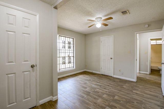 9923 Valley Sun Dr, Houston, TX 77078 - unfurnished bedroom featuring wood finished floors, a textured ceiling, baseboards, and a ceiling fan