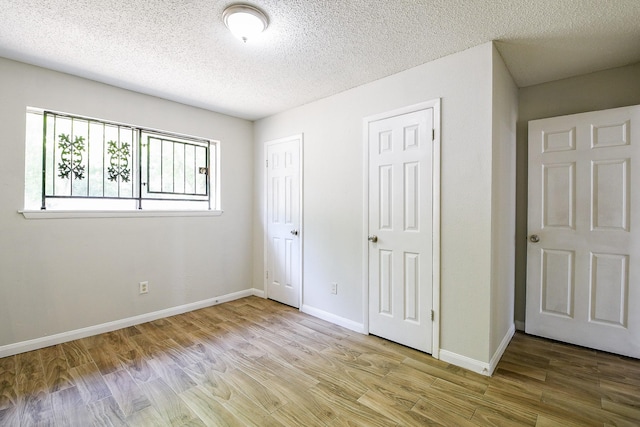 9923 Valley Sun Dr, Houston, TX 77078 - unfurnished bedroom featuring wood finished floors, a textured ceiling, and baseboards