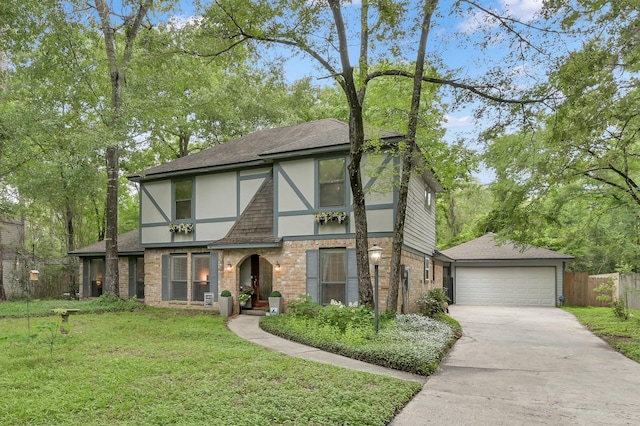 tudor house with stucco siding, brick siding, a shingled roof, and driveway