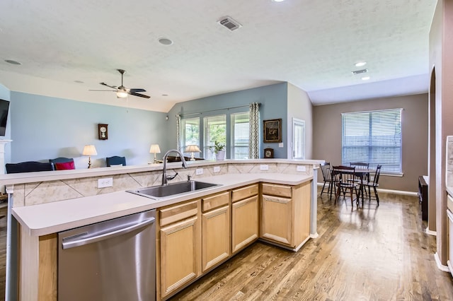 18115 Linden Forest Ln, Katy, TX 77449 - kitchen featuring stainless steel dishwasher, a sink, open floor plan, light wood-style flooring, and light countertops