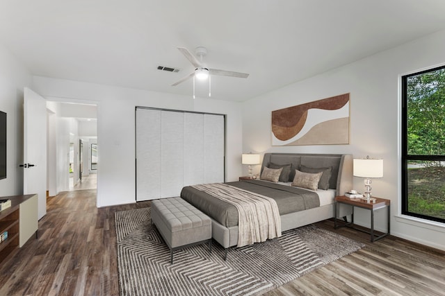 bedroom with wood finished floors, a closet, ceiling fan, and baseboards