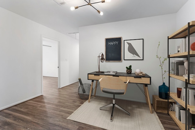 home office featuring wood finished floors, a chandelier, attic access, and baseboards