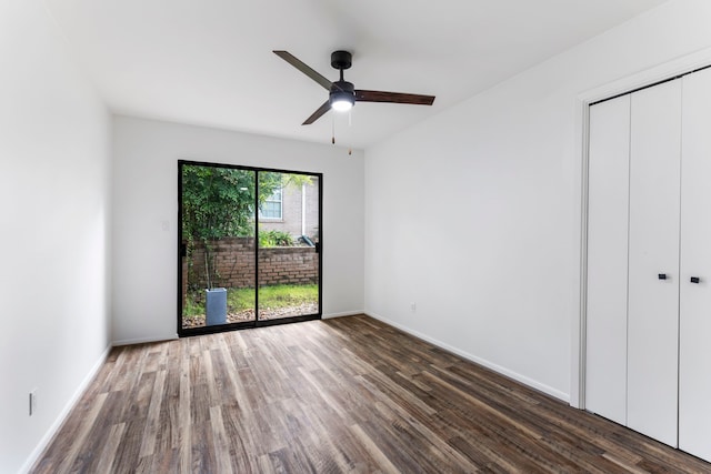 unfurnished bedroom featuring wood finished floors, baseboards, a closet, and a ceiling fan