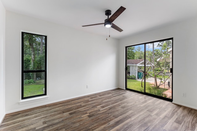 unfurnished room with wood finished floors, ceiling fan, and baseboards