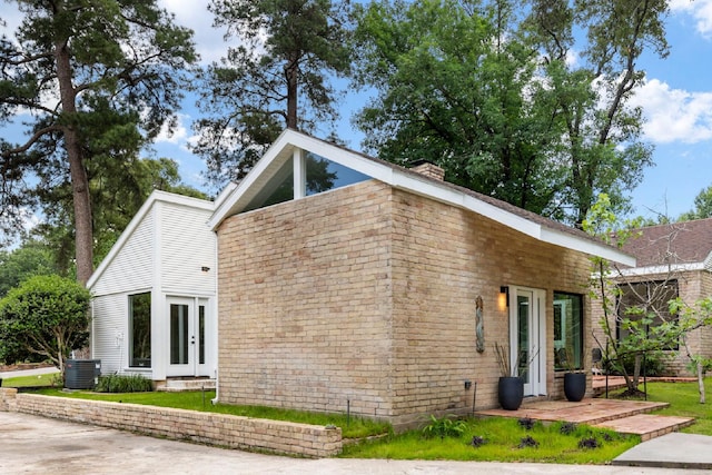 view of home's exterior featuring central AC unit and a chimney