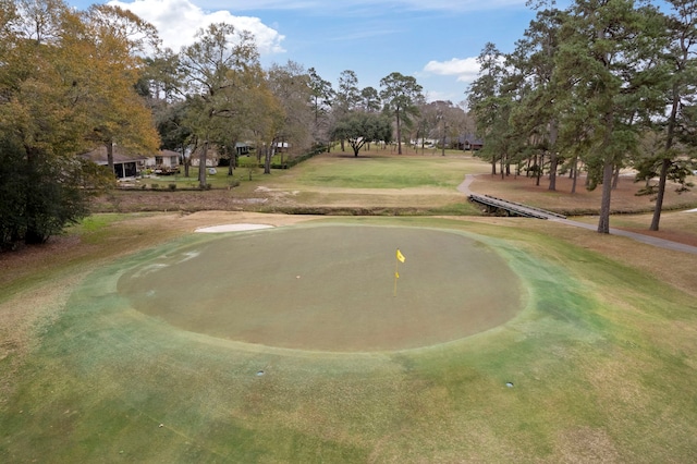 view of property's community featuring golf course view and view of scattered trees