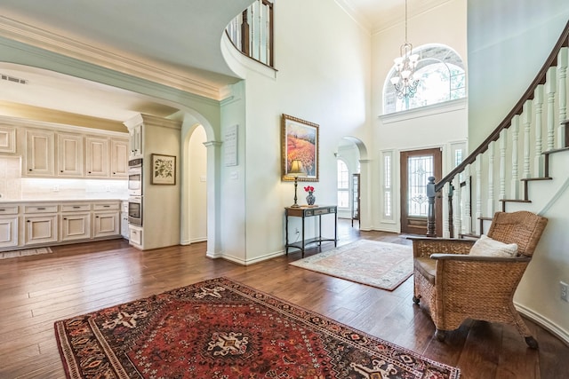 147 Sunnyvale W, Montgomery, TX 77356 - entryway featuring arched walkways, dark wood-style flooring, crown molding, a high ceiling, and a chandelier