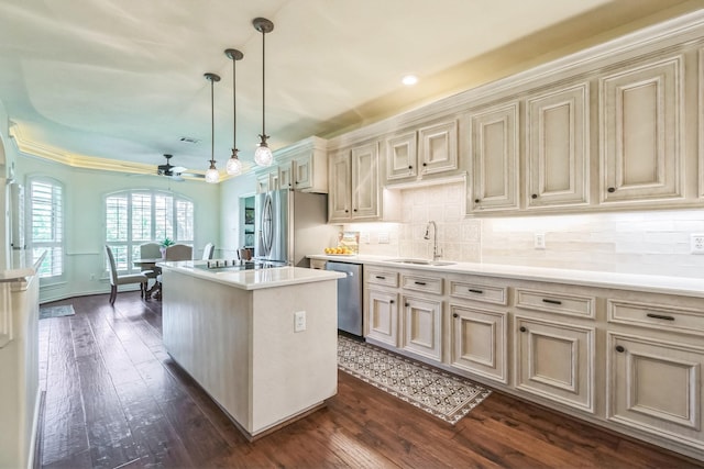 147 Sunnyvale W, Montgomery, TX 77356 - kitchen featuring cream cabinets, a sink, a ceiling fan, appliances with stainless steel finishes, and a kitchen island