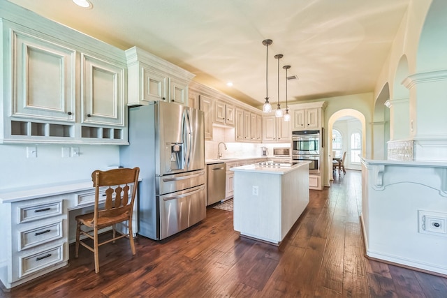 147 Sunnyvale W, Montgomery, TX 77356 - kitchen with appliances with stainless steel finishes, arched walkways, a kitchen island, light countertops, and dark wood-style floors