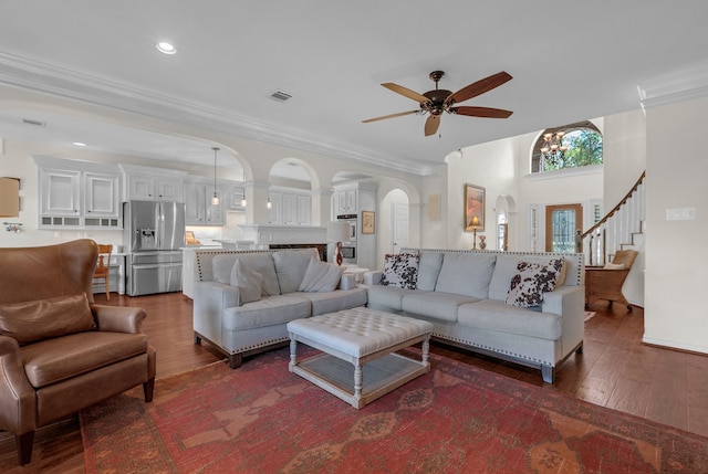 147 Sunnyvale W, Montgomery, TX 77356 - living room featuring arched walkways, ceiling fan, dark wood-style flooring, ornamental molding, and stairs