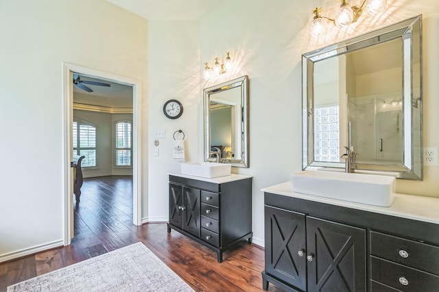 147 Sunnyvale W, Montgomery, TX 77356 - bathroom featuring wood finished floors, two vanities, baseboards, a ceiling fan, and a shower with door
