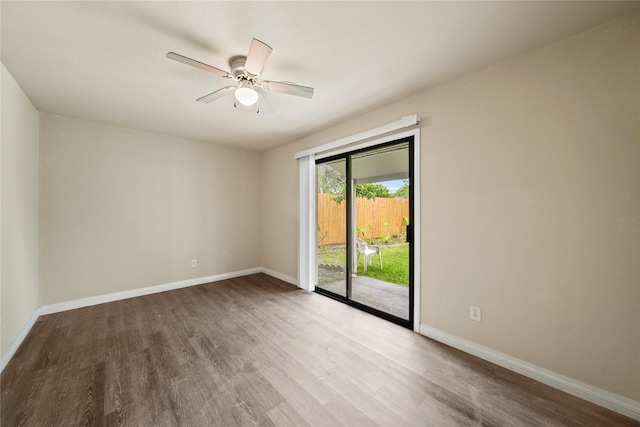 spare room with wood finished floors, baseboards, and a ceiling fan