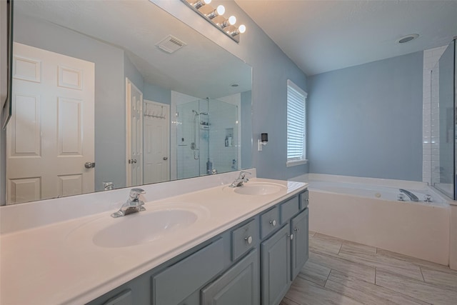 bathroom featuring a stall shower, double vanity, and a garden tub