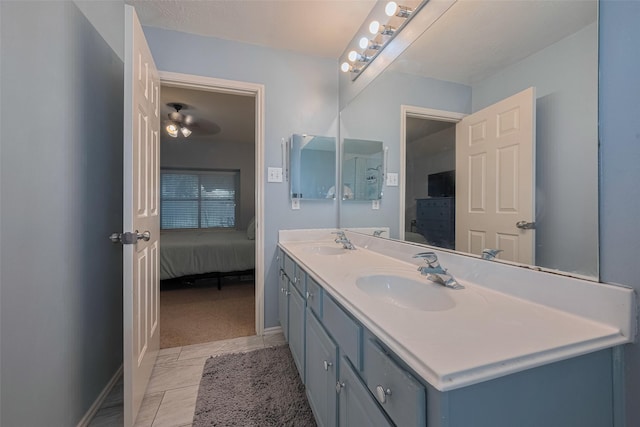 bathroom with ensuite bath, baseboards, and double vanity