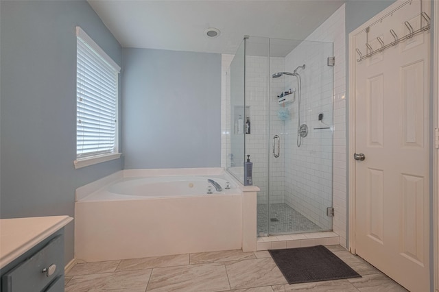 full bath featuring a garden tub, vanity, and a stall shower