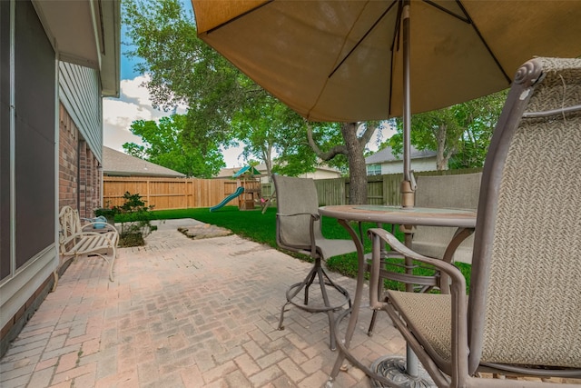 view of patio featuring a playground and a fenced backyard