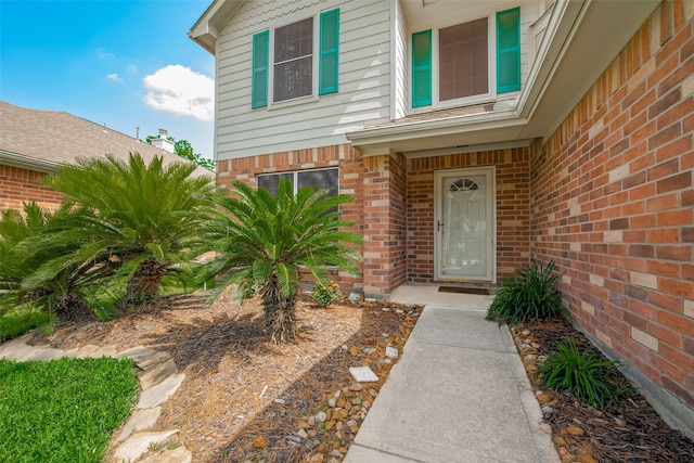 doorway to property featuring brick siding