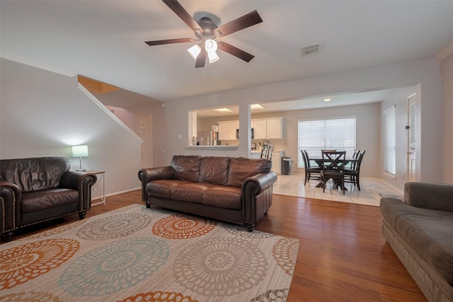 living room with a ceiling fan, wood finished floors, and baseboards