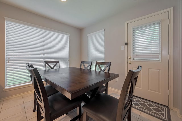 dining space with light tile patterned flooring and baseboards