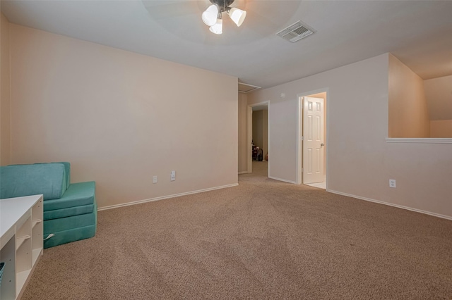 unfurnished room featuring carpet floors, a ceiling fan, attic access, and baseboards