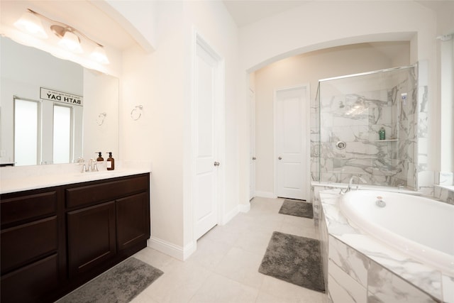 full bathroom featuring a shower stall, a garden tub, vanity, baseboards, and tile patterned flooring