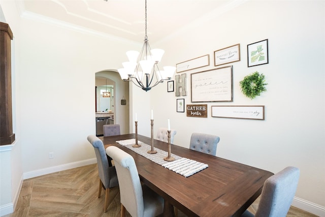 dining area with a chandelier, ornamental molding, arched walkways, and baseboards
