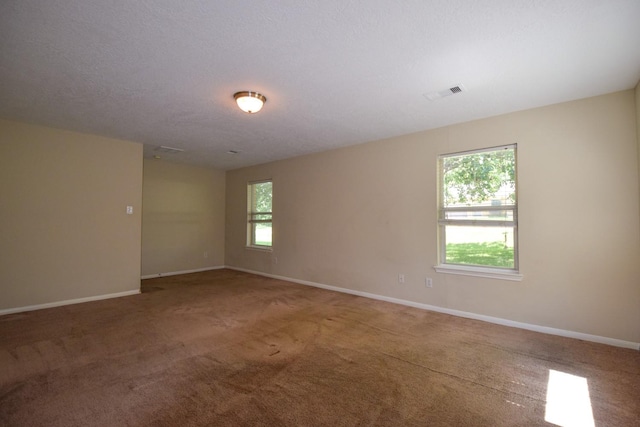 carpeted empty room featuring healthy amount of natural light and baseboards