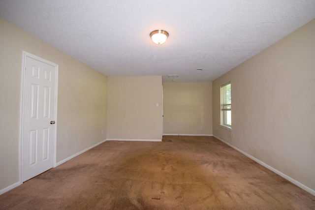 unfurnished room featuring carpet floors, baseboards, and a textured ceiling