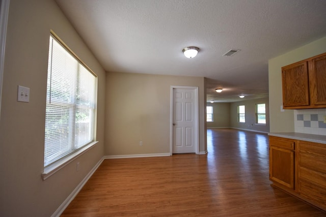 spare room featuring wood finished floors, baseboards, and a textured ceiling