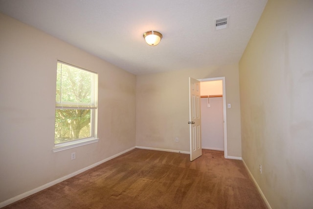 carpeted spare room featuring baseboards