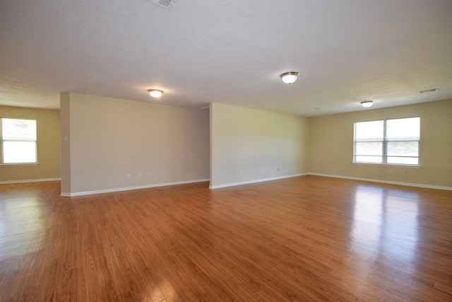 unfurnished room with wood finished floors and baseboards