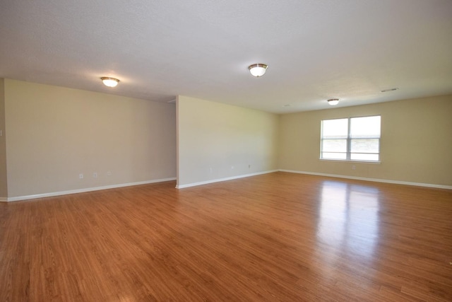 unfurnished room featuring wood finished floors and baseboards