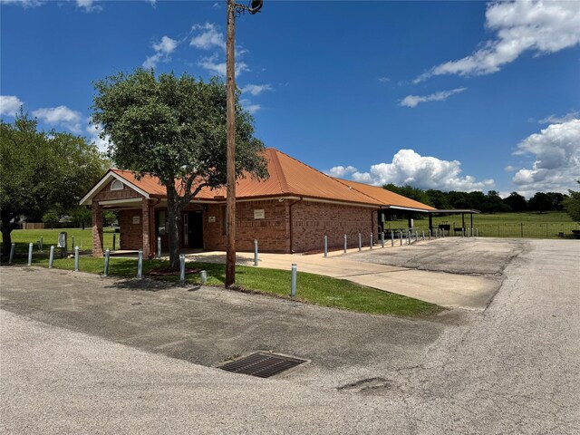 view of front of home featuring brick siding, fence, and metal roof
