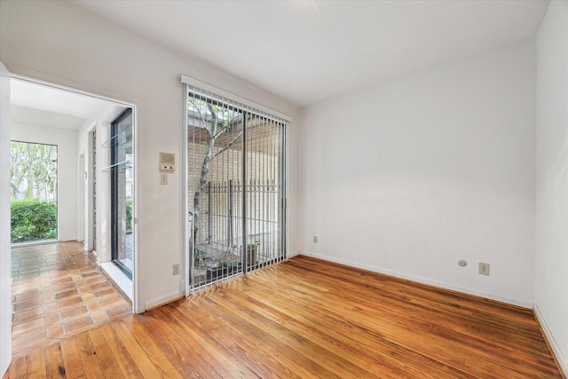 unfurnished room with light wood-type flooring and baseboards