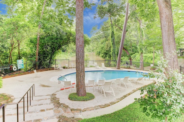 community pool featuring fence and a patio area