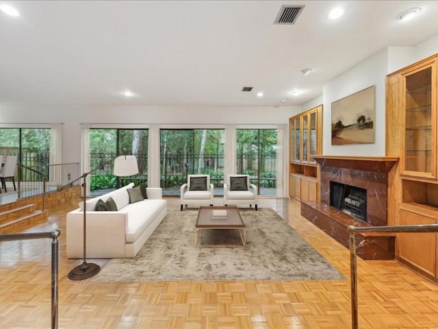living room featuring healthy amount of natural light, a premium fireplace, and recessed lighting