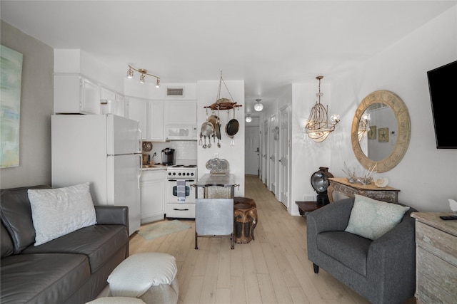 6102 Seawall Blvd Unit 290, Galveston, TX 77551 - living room featuring light wood finished floors and a chandelier