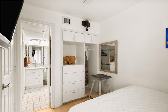 6102 Seawall Blvd Unit 290, Galveston, TX 77551 - bedroom with a closet, light wood-style flooring, and connected bathroom