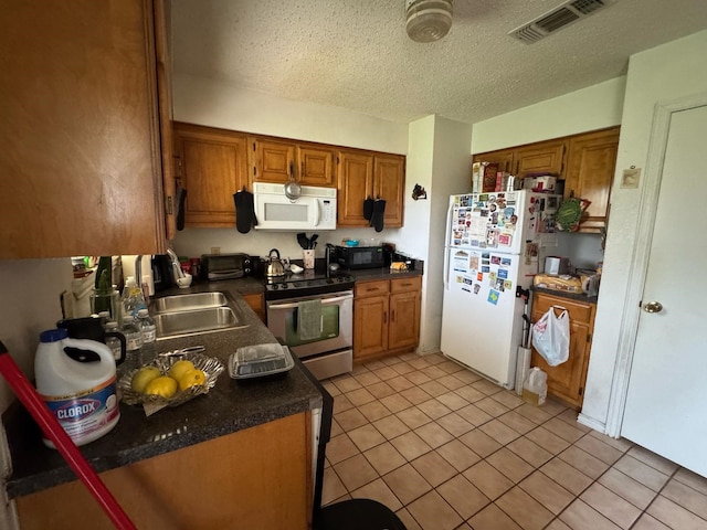 1450 Allegro Dr, Dallas, TX 75241 - kitchen featuring white appliances, dark countertops, brown cabinets, light tile patterned floors, and a textured ceiling