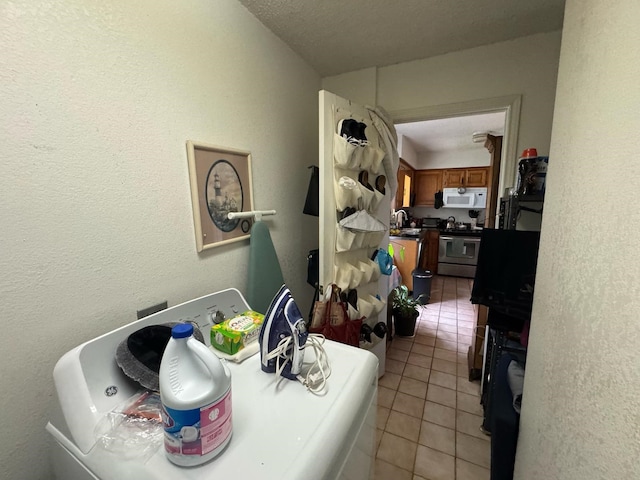 1450 Allegro Dr, Dallas, TX 75241 - laundry area with washer / clothes dryer, light tile patterned flooring, and a textured wall