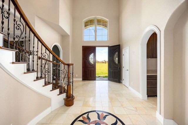 4343 Schlipf Rd, Katy, TX 77493 - foyer entrance featuring a high ceiling, healthy amount of natural light, arched walkways, baseboards, and stairs