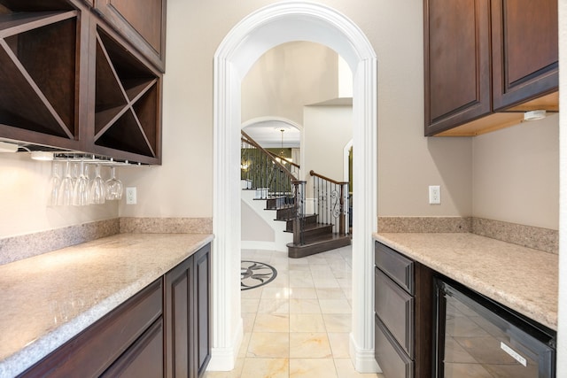 4343 Schlipf Rd, Katy, TX 77493 - indoor dry bar with wine cooler, stairway, light marble finish flooring, and arched walkways