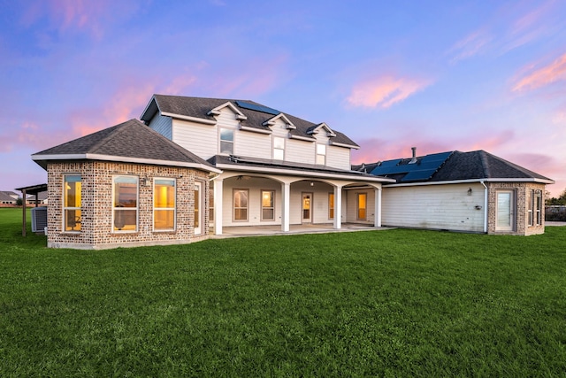 4343 Schlipf Rd, Katy, TX 77493 - rear view of property featuring solar panels, a patio, a lawn, and brick siding