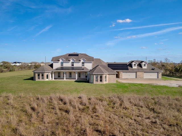 4343 Schlipf Rd, Katy, TX 77493 - back of property with dirt driveway, a lawn, solar panels, an attached garage, and brick siding