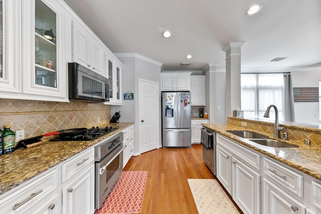 1708 Wilson St, Houston, TX 77019 - kitchen with appliances with stainless steel finishes, a sink, ornamental molding, white cabinets, and backsplash