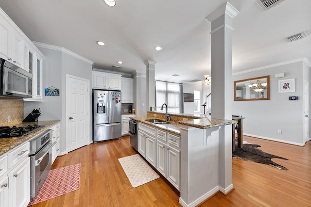1708 Wilson St, Houston, TX 77019 - kitchen with appliances with stainless steel finishes, decorative columns, a sink, crown molding, and backsplash